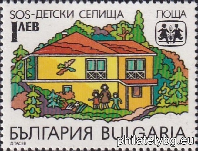 A house from a childrens village, children with a mother, the organizations emblem.